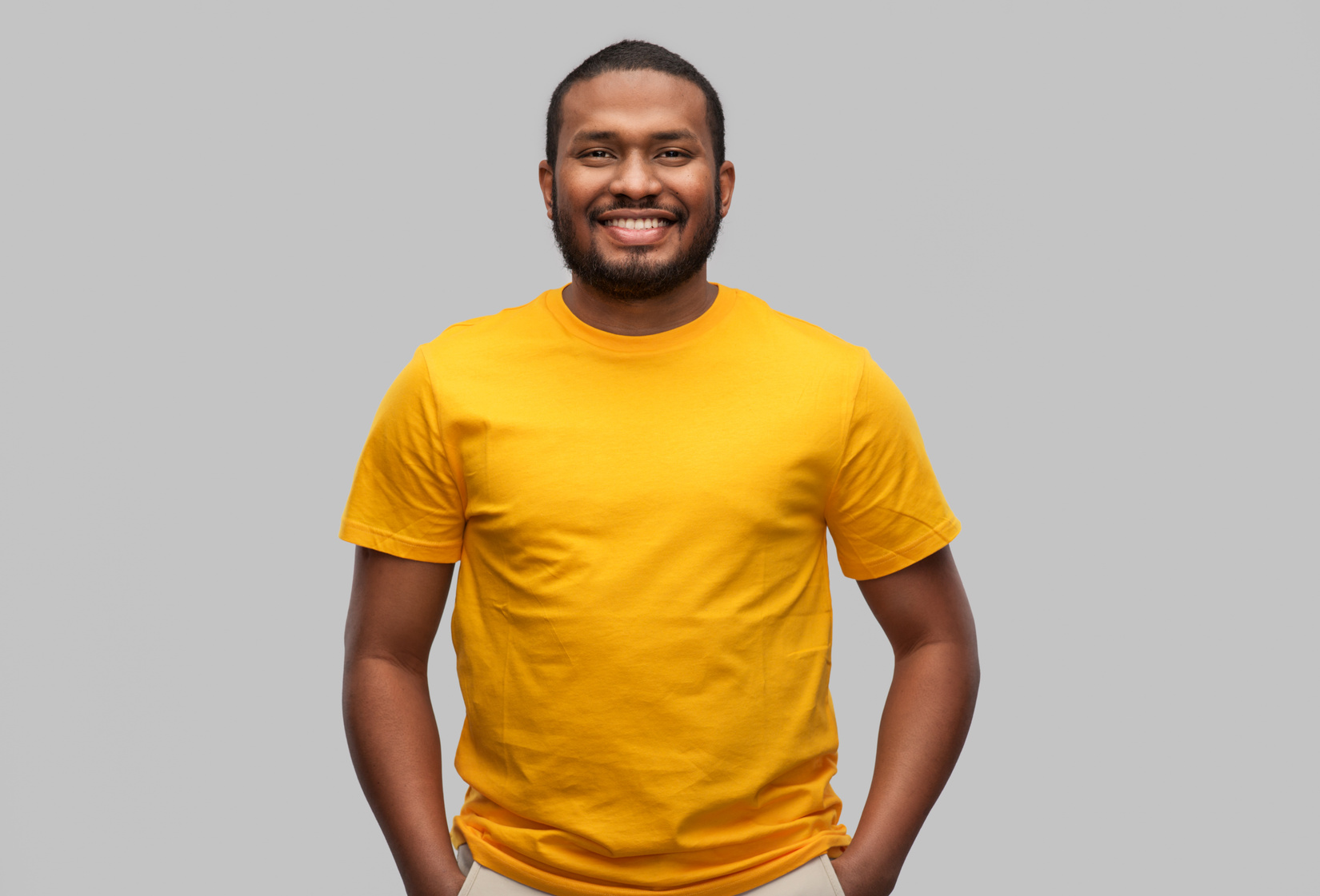 Man in Yellow T-Shirt on Grey Background 