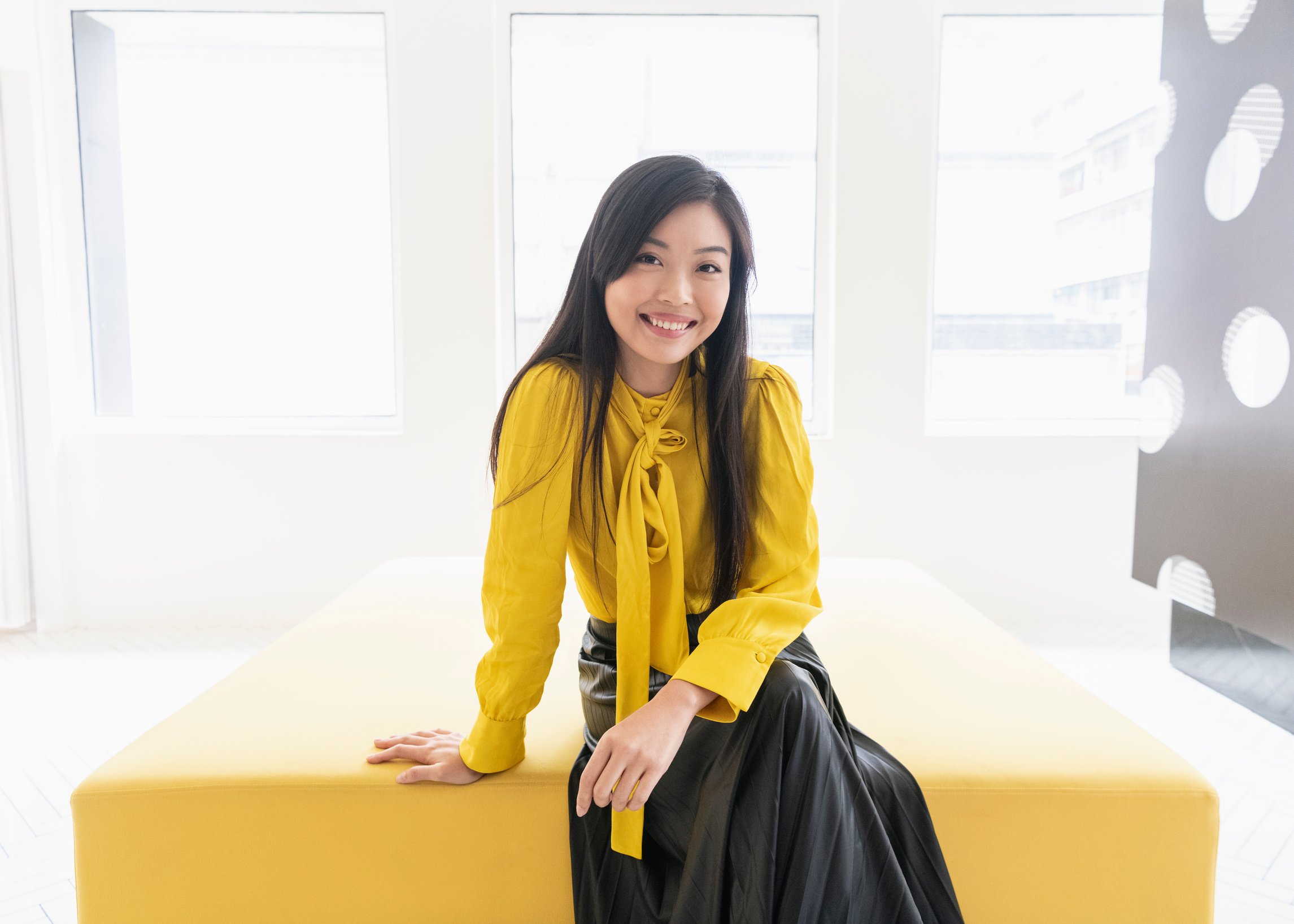 Cheerful Chinese woman wearing yellow blouse